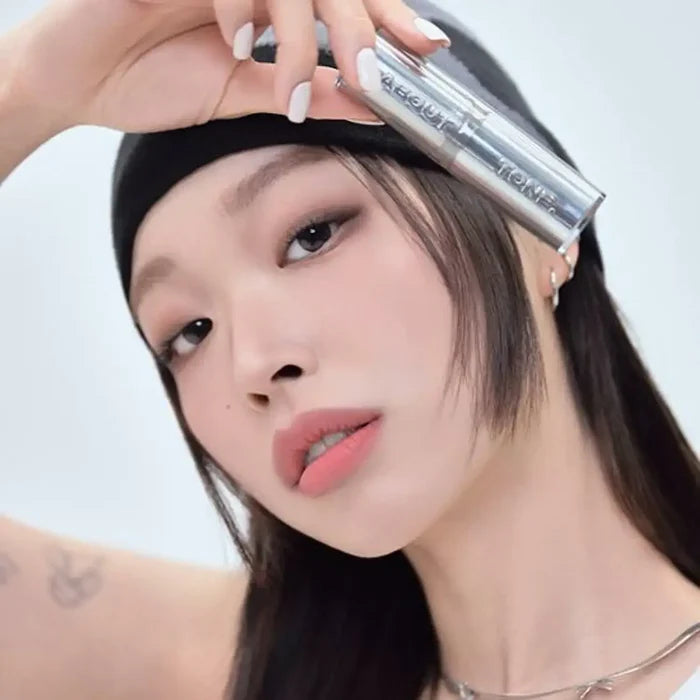 Woman holding ABOUT TONE Blur Lasting Stick Primer