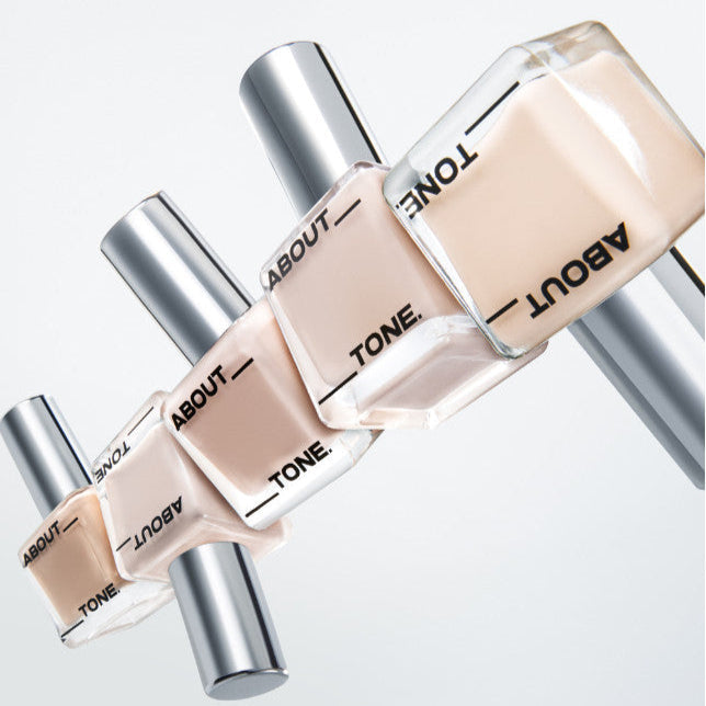 ABOUT TONE Skin Layer Fit Foundation bottles in various shades on white background, showcasing premium coverage.