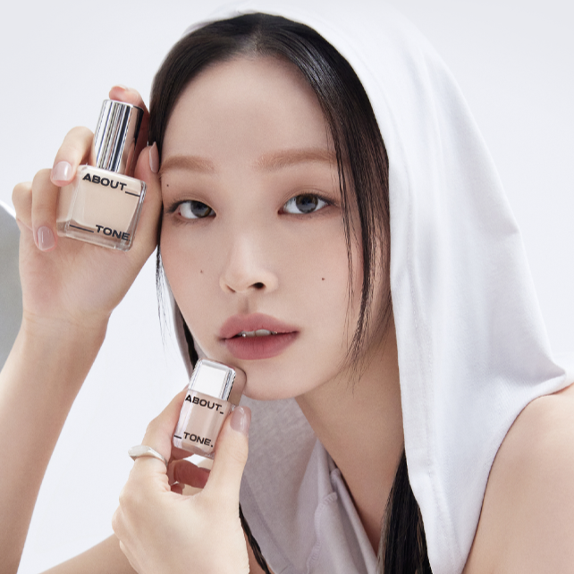 Woman holding ABOUT TONE Skin Layer Fit Foundation bottles for smooth complexion