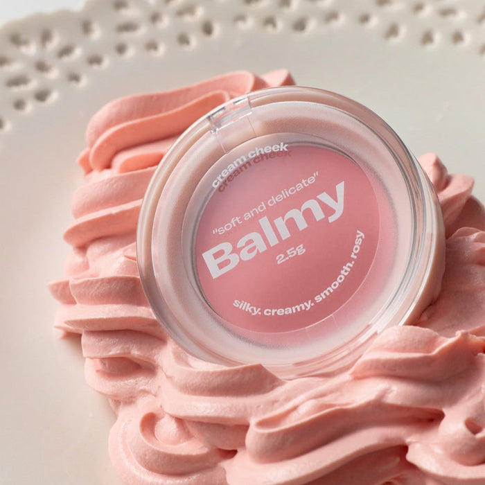 ALTERNATIVE STEREO Balmy Cream Cheek on decorative pink cream swirls, highlighting its smooth and delicate texture.