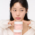 Woman holding AND:AR Centellian in Cica Calming Pads, 70 sheets, skincare product on display