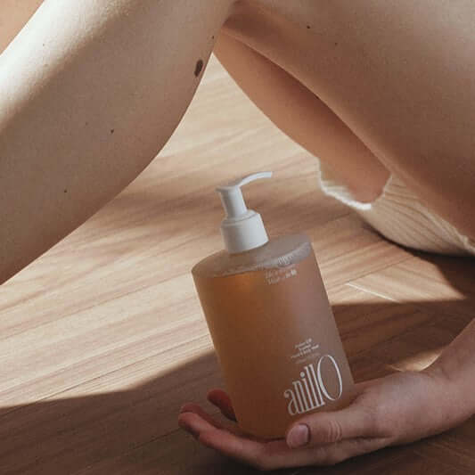 ANILLO Amber528 Scented Hand & Body Wash 450ml bottle held on wooden floor