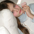 Person holding AOU Soft Cream Blush, showcasing soft pink tones on cheeks, enhancing natural beauty with gentle makeup look.