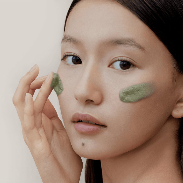 Woman applying ARENCIA Green Tea + LHA Deep Pore Rice Cake Soap 150ml on face