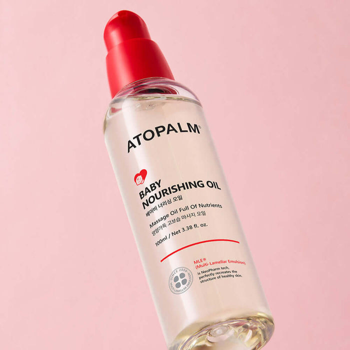 ATOPALM Baby Nourishing Oil 100ml bottle on pink background.