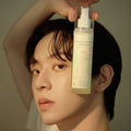 Model holding AXIS-Y Dark Spot Correcting Glow Toner 125ml bottle, skincare product for glowing skin and dark spot correction