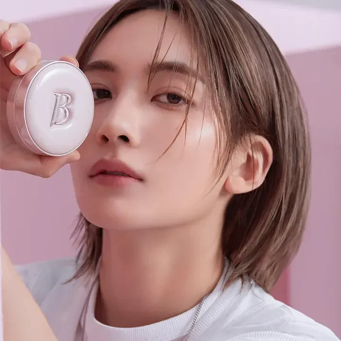 Person holding BANILACO Essence Skin Pink Cushion in hand, showcasing makeup product with pink background and packaging.