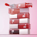 Stack of BANILA CO Hydrating Lip Oil bottles with applicator displayed