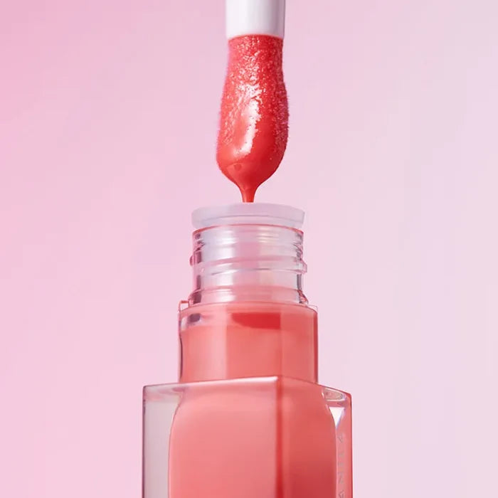 BANILA CO Hydrating Lip Oil with open applicator against pink background