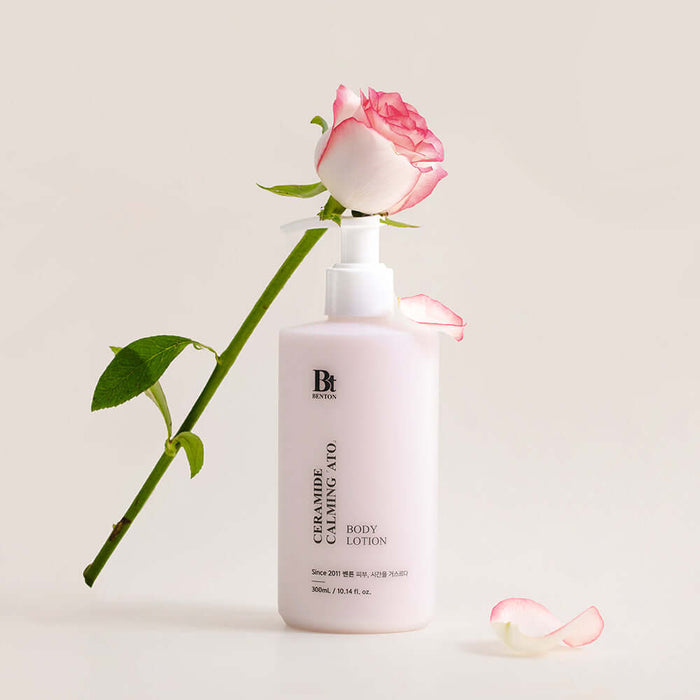 BENTON Ceramide Calming Ato Body Lotion 300ml beside a pink rose on a white background.