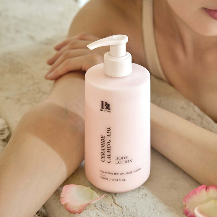 BENTON Ceramide Calming Ato Body Lotion 300ml bottle on table with person relaxing nearby