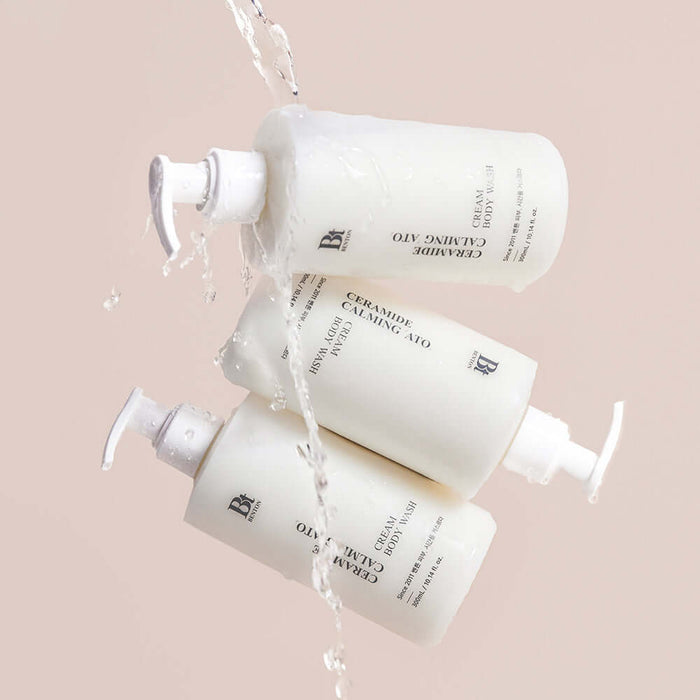 BENTON Ceramide Calming Ato Cream Body Wash 300ml bottles with water pouring over them, showcasing packaging and texture.