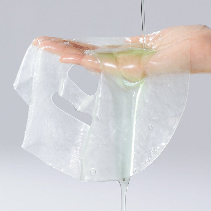Close-up of a CELIMAX Cica Serum Mask sheet being held, highlighting texture and serum.