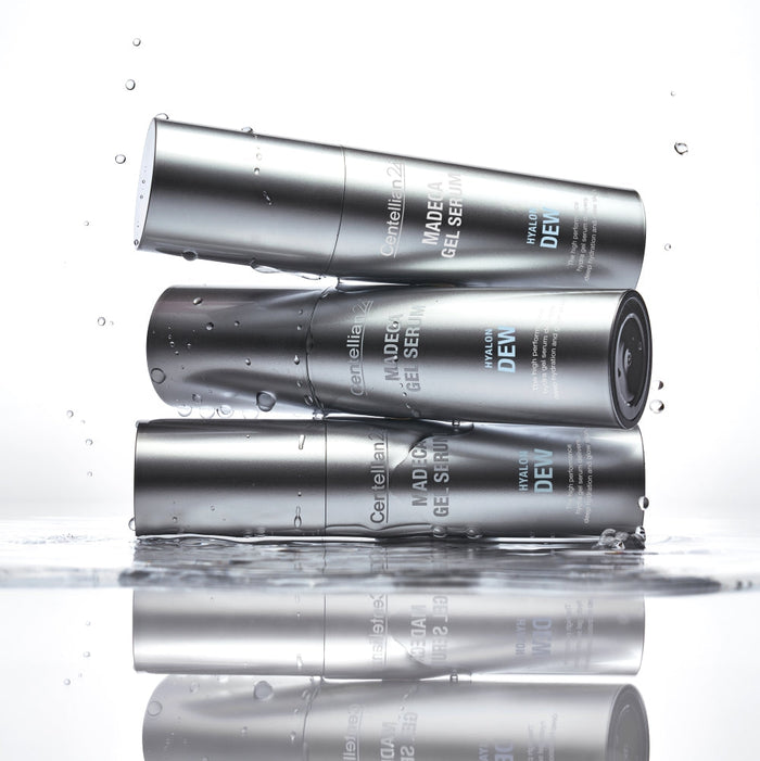 Three bottles of CENTELLIAN 24 Madeca Gel Serum Hyalon Dew 30ml stacked with water droplets, showcasing the product’s design and texture.