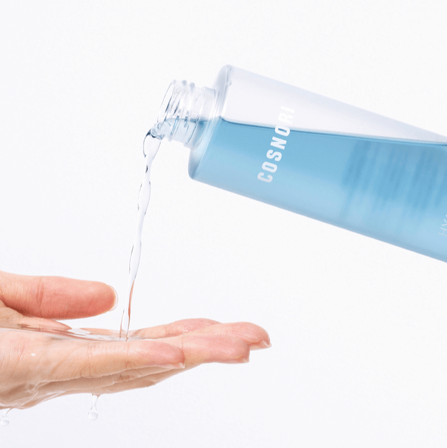 COSNORI Hyaluronic Moisture Toner 200ml being poured into a hand, demonstrating the toner's texture and hydrating formula.