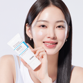 Woman applying COSRX The Ceramide Skin Barrier Moisturizer to her face, holding the product in hand.