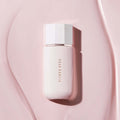 DEAR DAHLIA Prime Layer Glow Primer bottle on pink surface