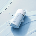 DEAR DAHLIA Sun Breeze Hydro Sun Lotion on smooth blue background with water droplets