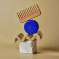 Wooden comb and DONGGUBAT Correct Shampoo Bar Cooling elegantly arranged on natural stone