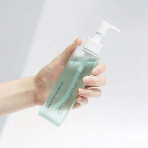 A hand holding a bottle of DR.ALTHEA Gentle Pore Cleansing Oil 150ml with pump dispenser.