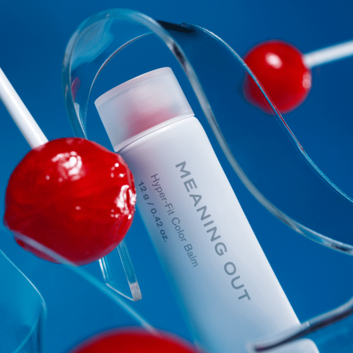 FEEV Hyper-Fit Color Balm with vibrant design, surrounded by red lollipops, offering a smooth and lasting color experience.