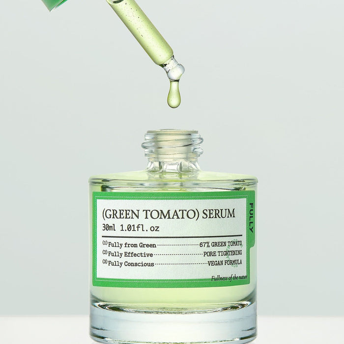 Bottle of FULLY Green Tomato Serum 30ml with dropper dispensing serum, vegan formula, skincare product.