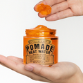 GRAFEN Pomande Neat Water 100g in open amber jar held by hands, glossy orange pomade scoop for men - Gentleman Korea
