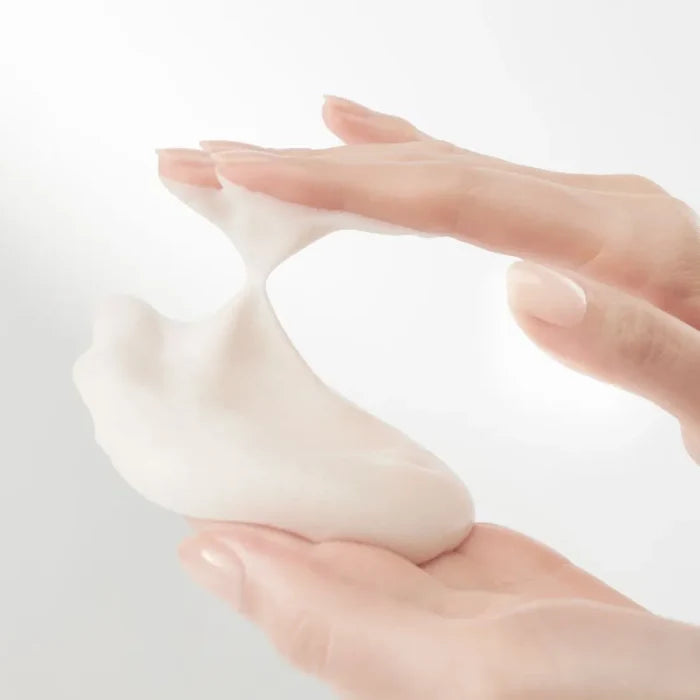 HANYUL Extreme Cream Cleansing Foam 200ml being applied with hands, showcasing its creamy texture.