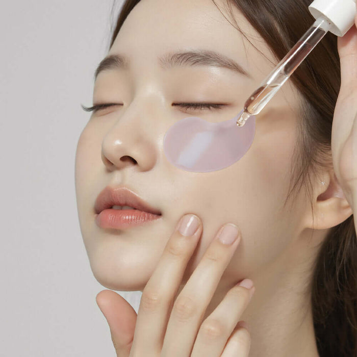 Woman applying HEIMISH RX Retinol Bakuchiol Hydrogel Eye Patches 60 Sheets for skincare
