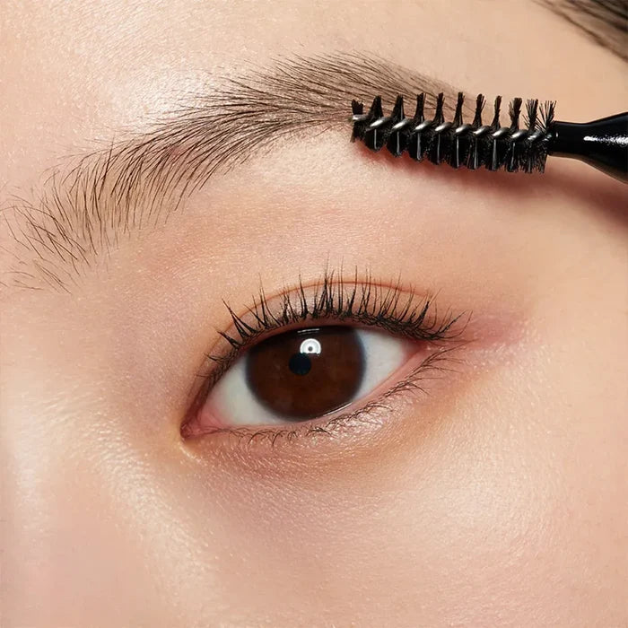 Close-up of eyebrow being brushed with HERA Brow Desighner Auto Pencil for perfect brow styling.