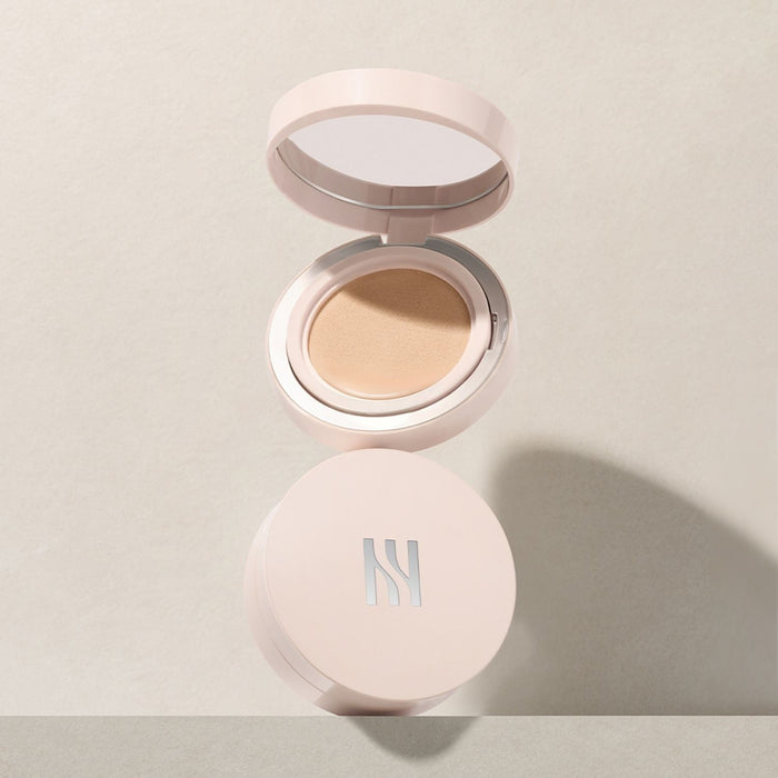 HERA Reflection Skin Glow Cushion Foundation 15g open on beige background, showcasing the product design and compact size.