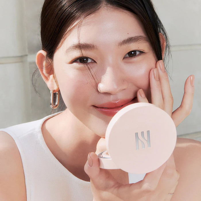 Woman applying HERA Reflection Skin Glow Cushion Foundation 15g for a natural glow