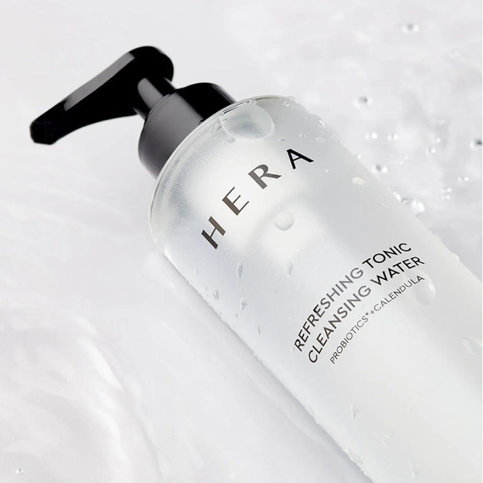 HERA Refreshing Tonic Cleansing Water 200ml bottle on a white surface with water droplets.