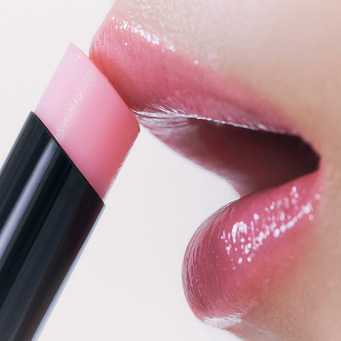 Close-up of lips applying HERA Sensual Nude Balm 3.5g for a natural look.