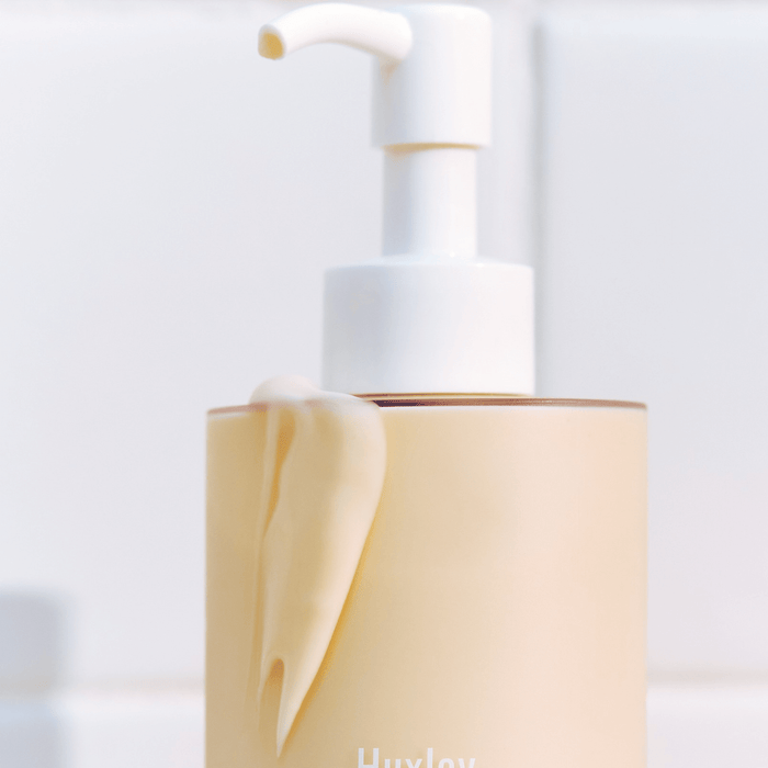 Bottle of HUXLEY Body Lotion Blue Madina Tangerine with pump on a white background.