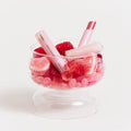HUXLEY Lip Balm Leave Behide in glass bowl with pink decorative candies