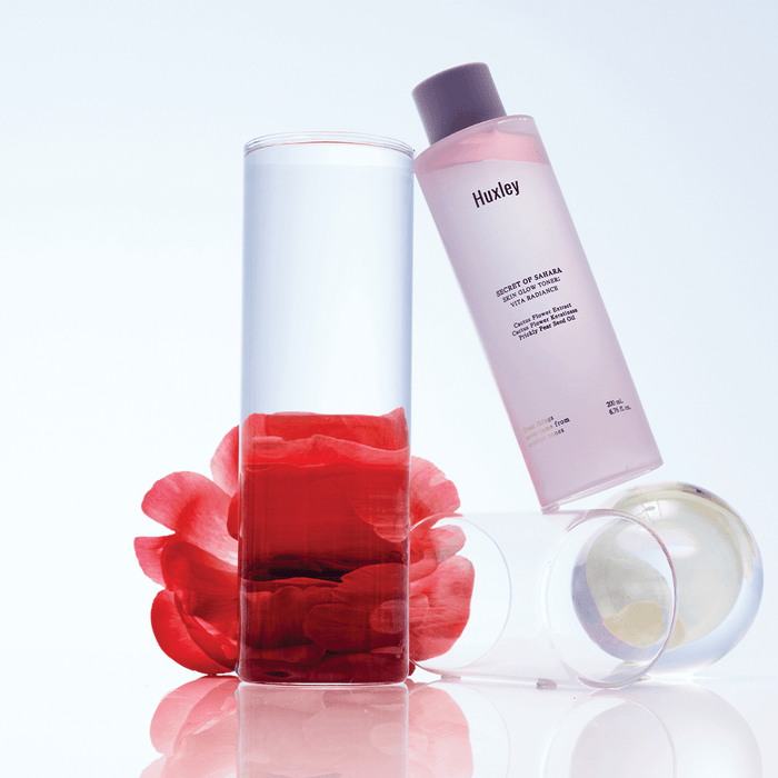 HUXLEY Skin Glow Toner Vita Radiance bottle with clear liquid and petals, promoting radiant skin.