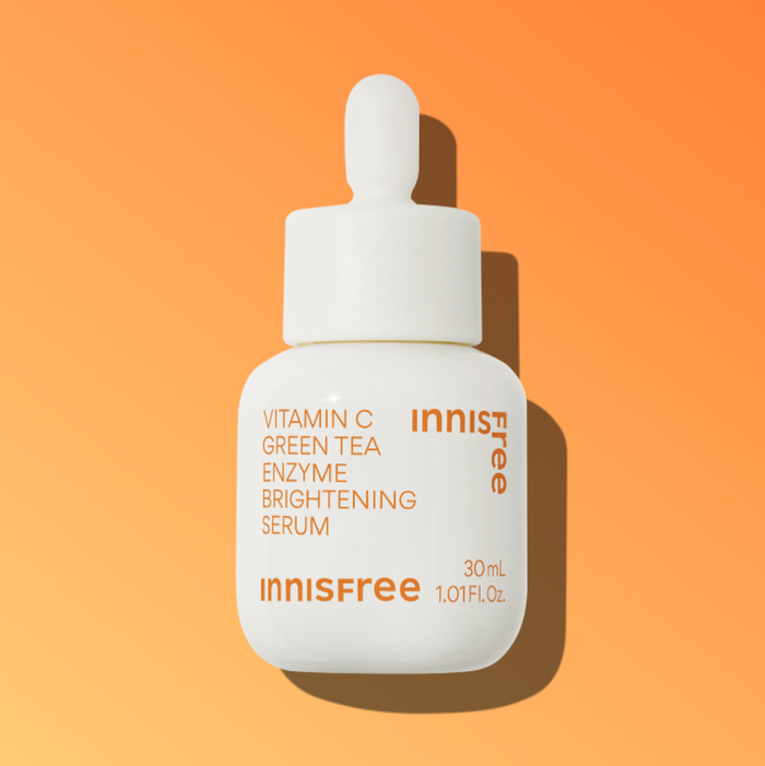 INNISFREE Vitamin C Green Tea Enzyme Brightening Serum bottle on orange background