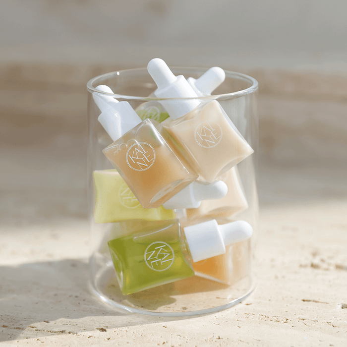 KAINE Serum Discovery Kit featuring various serum bottles in a glass container, perfect for skincare enthusiasts.