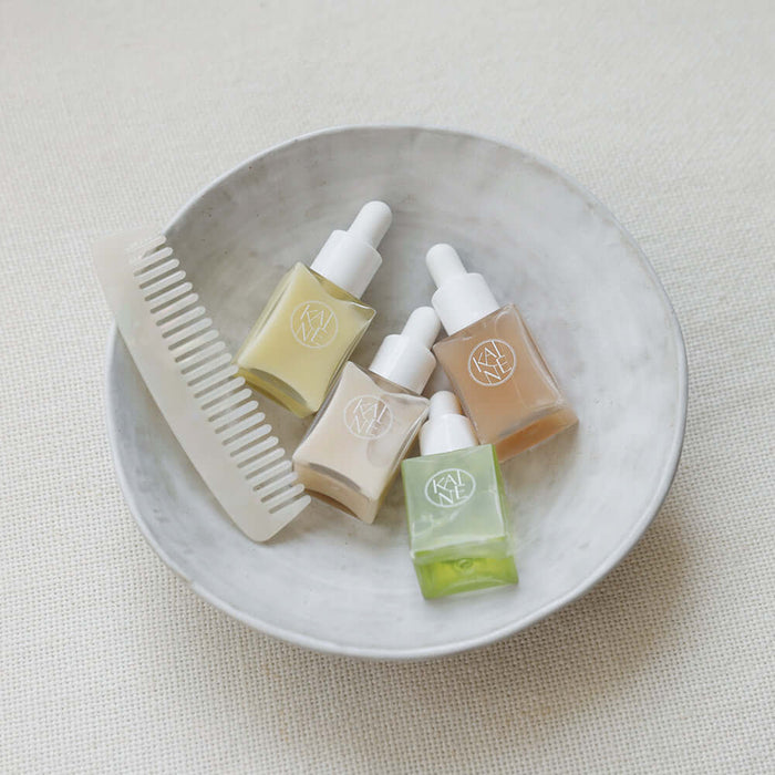 KAINE Serum Discovery Kit displayed with skincare serums and a comb in a dish for beauty routine.