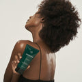 Woman holding LADOR Herbalism Treatment 150ml with visible product label