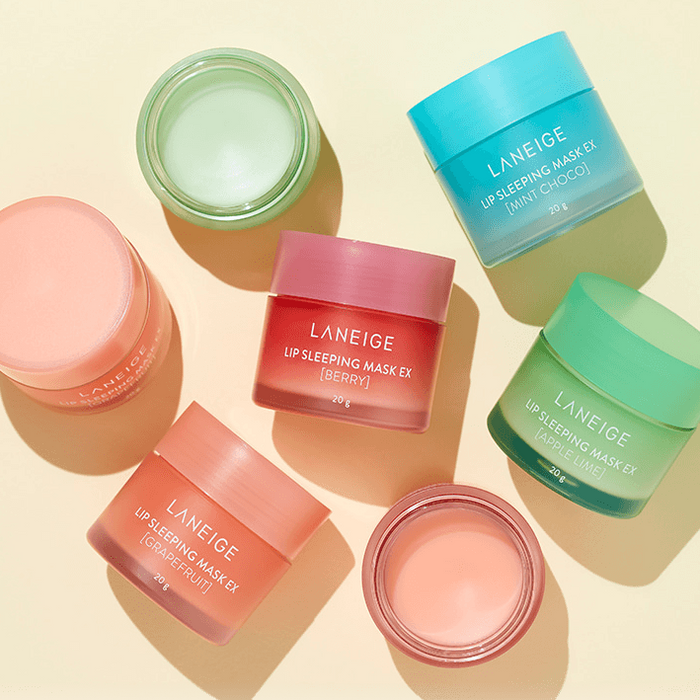 Assorted LANEIGE Lip Sleeping Mask EX jars on display in different colors and flavors, including berry, grapefruit, and mint choco.