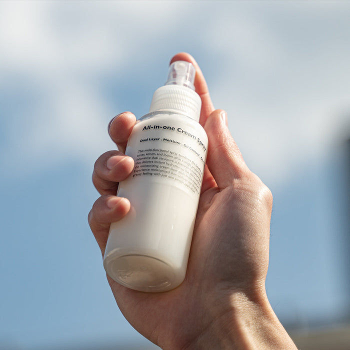 LAZY SOCIETY All-in-One Cream Spray 120ml held by hand against sky, Gentleman Korea men’s skincare product for gentlemen