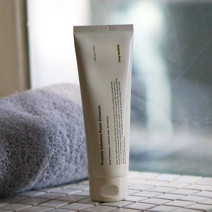 LAZY SOCIETY Trouble Solution Foam Cleanser 120ml tube on bathroom tile beside towel — Gentleman Korea men’s skincare product