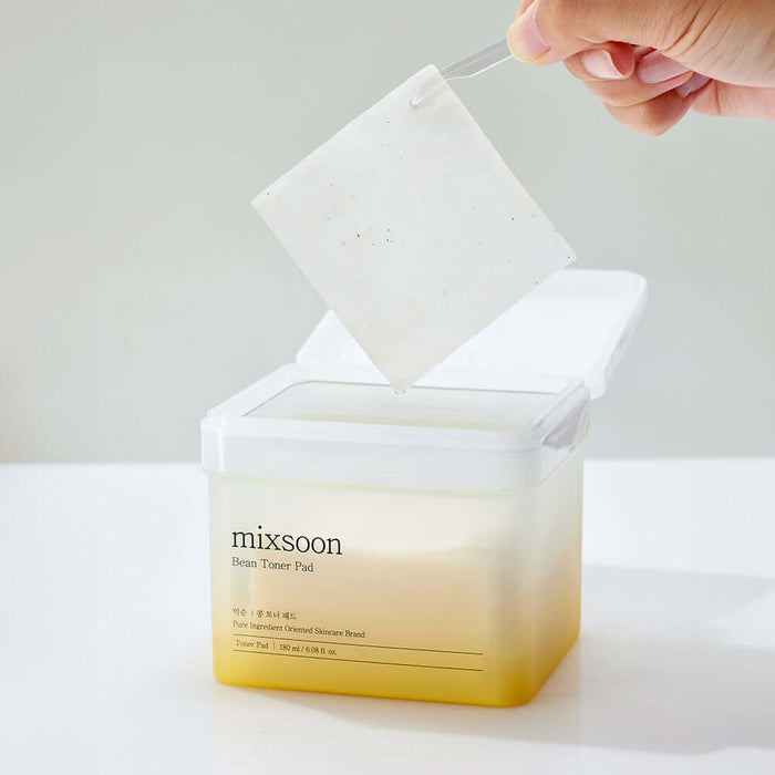 MIXSOON Bean Toner Pad being lifted from container, showcasing its texture.