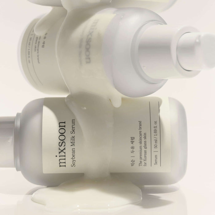 MIXSOON Soybean Milk Serum 50ml bottles with white liquid flowing over them, showcasing skincare product design and packaging.