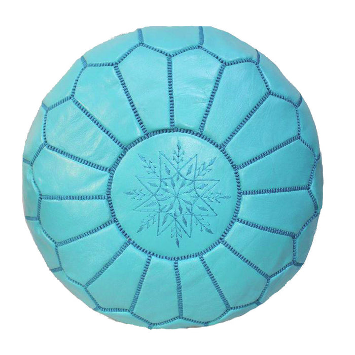 A round, turquoise Moroccan leather ottoman with intricate embroidered designs and a snowflake pattern in the center.