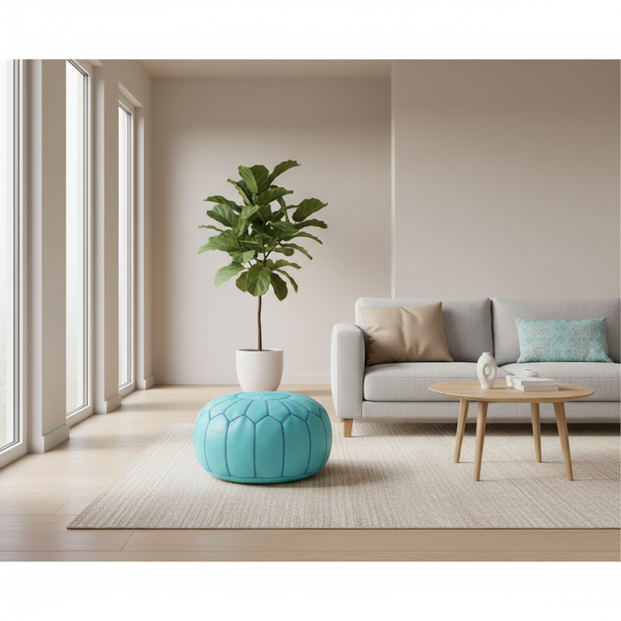 Modern living room with a gray sofa, turquoise pouf, and a plant.