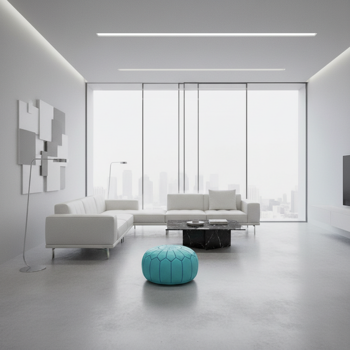 Modern living room with white furniture and a turquoise pouf.