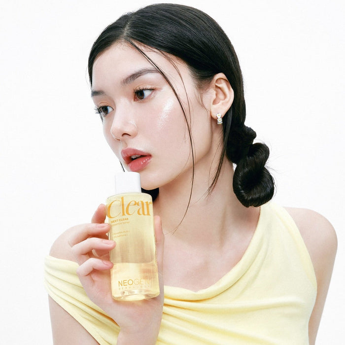 Woman holding NEOGEN Next Clear Essence Toner 210ml with glowing skin